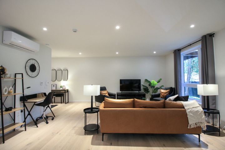 Aire ouverte du Condo 104 au 800 St-Jovite à Mont-Tremblant, avec salon, salle à manger et cuisine moderne dans un espace lumineux et fluide.