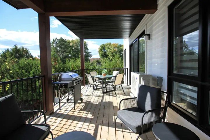 Terrasse privée spacieuse du Condo 200 au 800 St-Jovite à Mont-Tremblant, aménagée avec mobilier extérieur pour repas et détente au soleil.