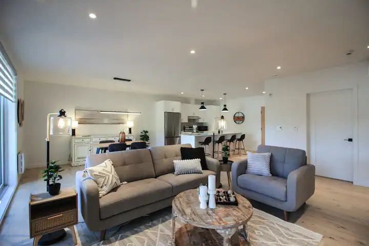 Salon lumineux du Condo 303 au 800 St-Jovite, avec mobilier moderne et ambiance apaisante, parfait pour se détendre à Mont-Tremblant.