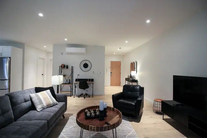 Vue du salon et de l’entrée du Condo 204 au 800 St-Jovite à Mont-Tremblant, espace lumineux et bien agencé pour un accueil chaleureux.