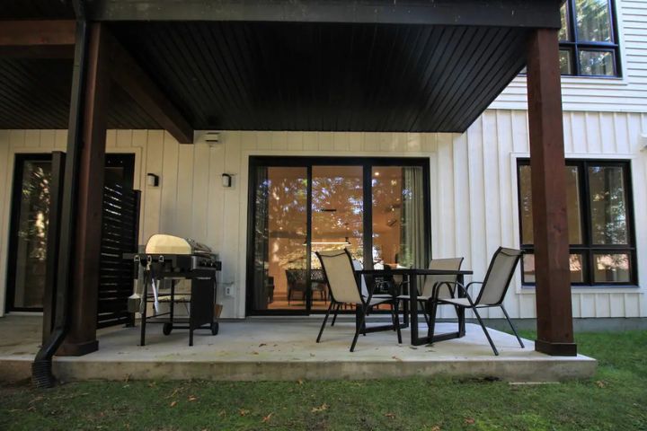 Terrasse privée du Condo 102 au 800 St-Jovite à Mont-Tremblant avec mobilier extérieur et BBQ, parfaite pour repas ou détente.